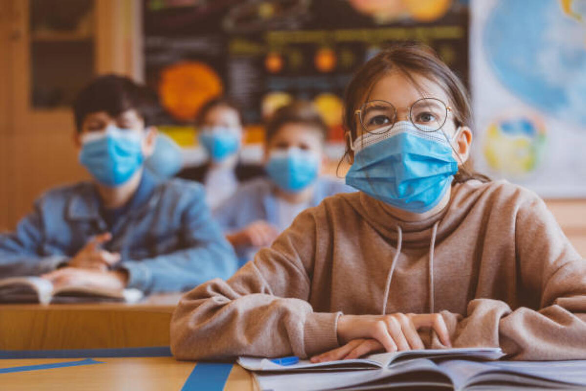 Ministro Bianchi, ecco la mia “classe pollaio” di Anna Angelucci - High school students at school, wearing N95 Face masks. Teenage girl wearing eyeglasses sitting at the school desk and listening to the teacher.