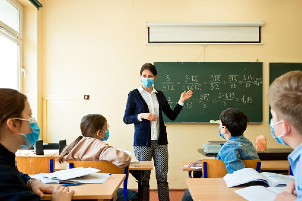 Scuola: "FDI, tanti proclami e pochi fatti in una gestione inaccettabile" - A teacher wearing a N95 Face masks teaches mathematics at an High School