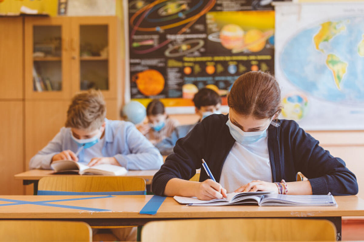 SBC eliminare le classi pollaio - High school students at school, wearing N95 Face masks.
Sitting in a classroom.