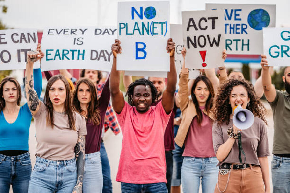 Clima, FLC CGIL: il 23 settembre sciopero per un diverso modello di sviluppo e per un’altra idea di società - Group of people protesting against climate change on the street. Holding placards and posters. Young woman speaking in megaphone.