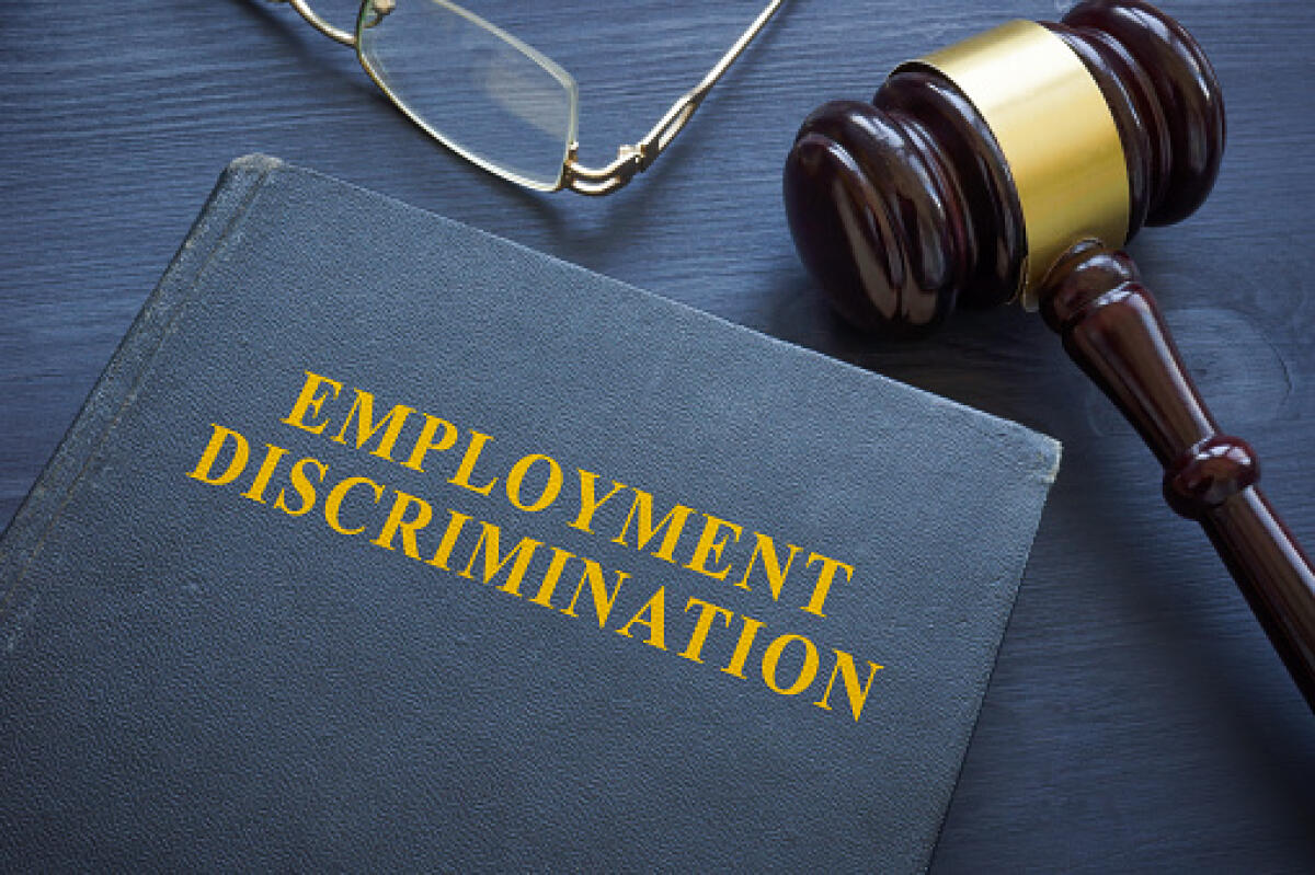 La discriminazione e la disparità di trattamento che i docenti di Discipline Audiovisive subiscono - Law about employment discrimination and a gavel on the table.