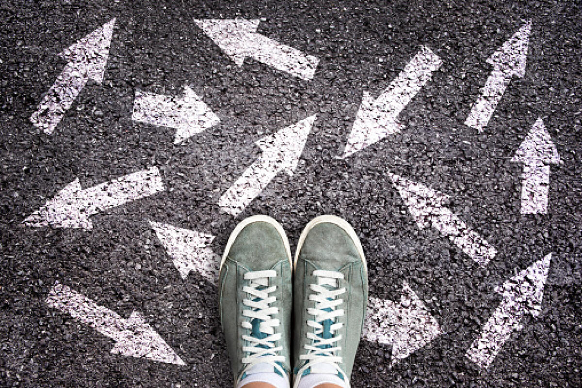 Iscrizioni per l’anno scolastico 2022/23: Come mai tanti giovani arrivano a pochi giorni cosi ancora incerti e confusi? - Sneaker shoes and arrows pointing in different directions on asphalt ground, choice concept