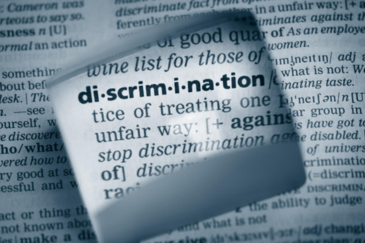 Iniziative per la Giornata contro la discriminazione 2023 - The Dictionary definition of the word “discrimination” photo taken through magnifying glass from a page of a dictionary with selective focus.