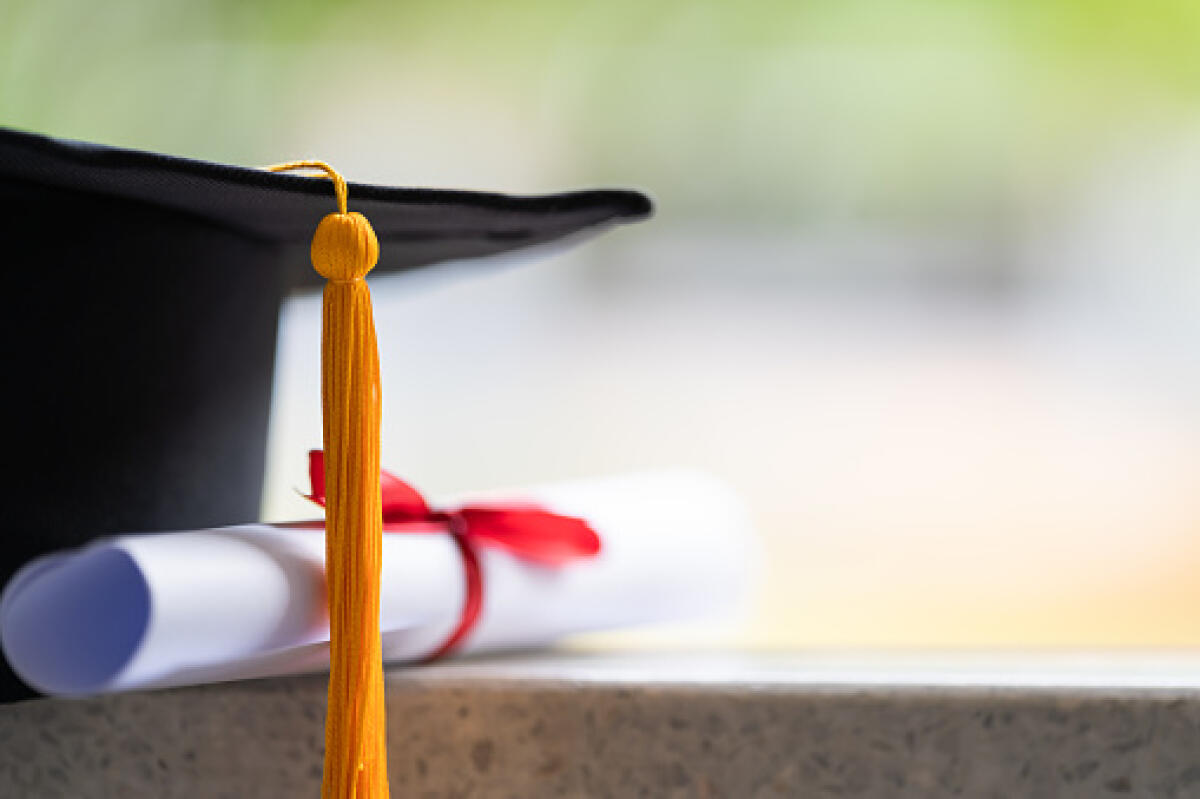 Riscatto della laurea in cambio di 900 euro per anno universitario svolto - Close-up of a mortarboard and degree certificate put on the table. Education stock photo