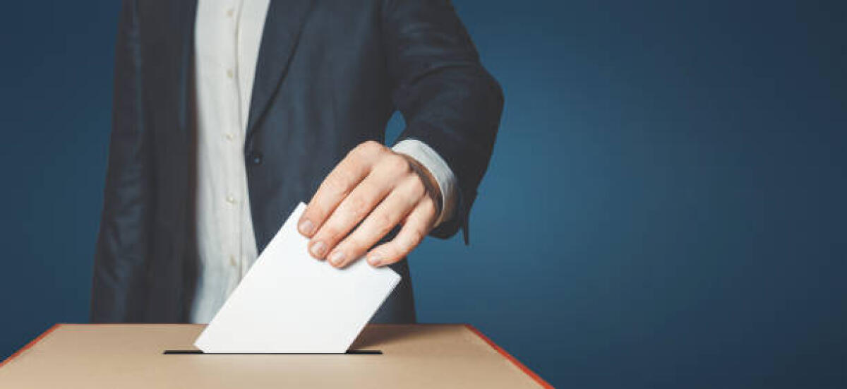 ANCoDiS: elezioni per rinnovo RSU, posizioni sindacali e voto per il cambiamento - Unrecognizable male voter holds in his hand a ballot above the ballot box