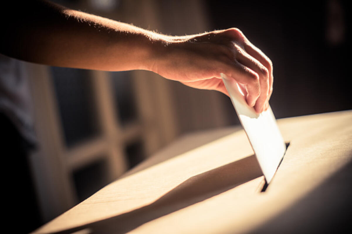 Referendum 8 e 9 giugno: un diritto civico da preservare, che i lavoratori della scuola non siano da meno - Conceptual image of a person voting, casting a ballot at a polling station, during elections.